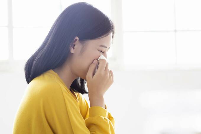 鼻をおさえる女性