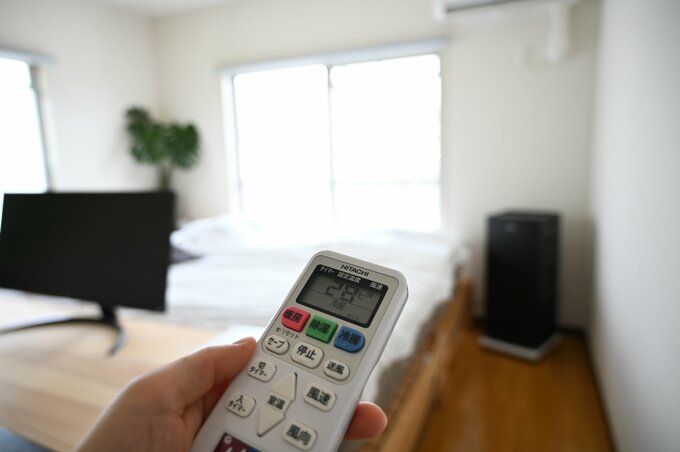エアコンのリモコンを操作する様子
