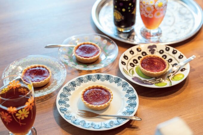 タルトや飲み物が入っていて、一つずつ柄が異なる皿やコップ
