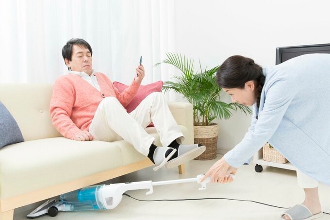 掃除機をかける妻とどける夫