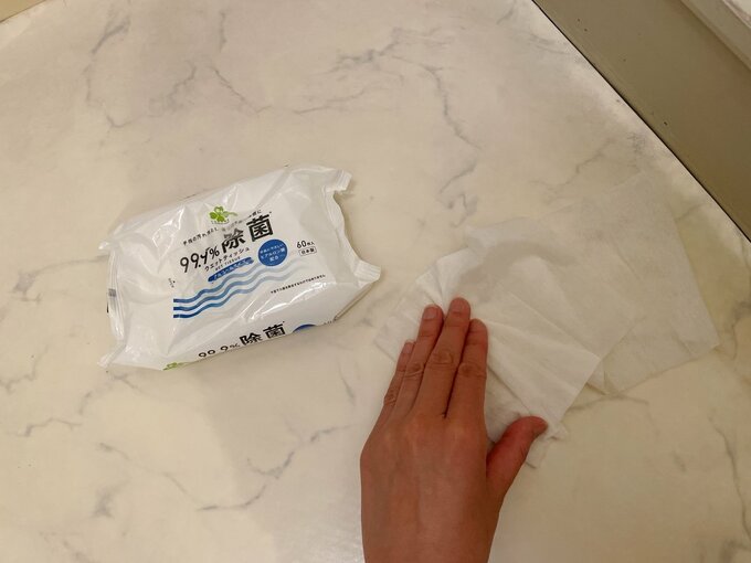 除菌シートで浴室の床を拭く