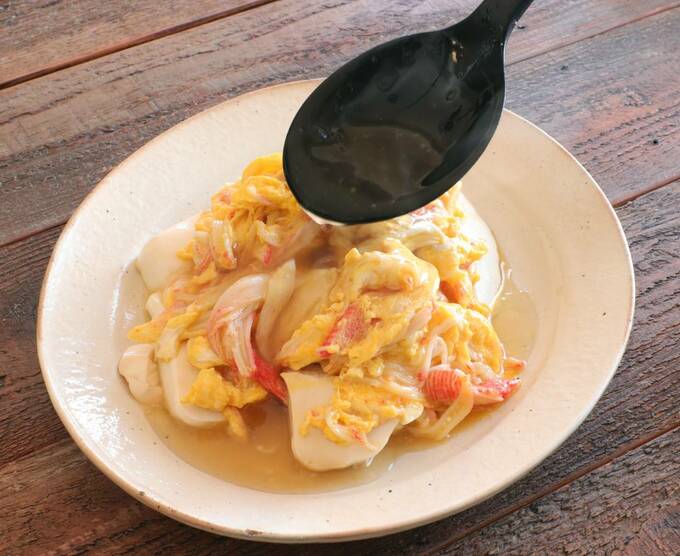 豆腐の上にカニ玉をすべらせる