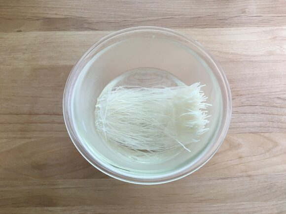 (1)　耐熱ボウルに春雨を入れ、熱湯（分量外）をかけて3分ほどおいて戻し、水気をよくきります。