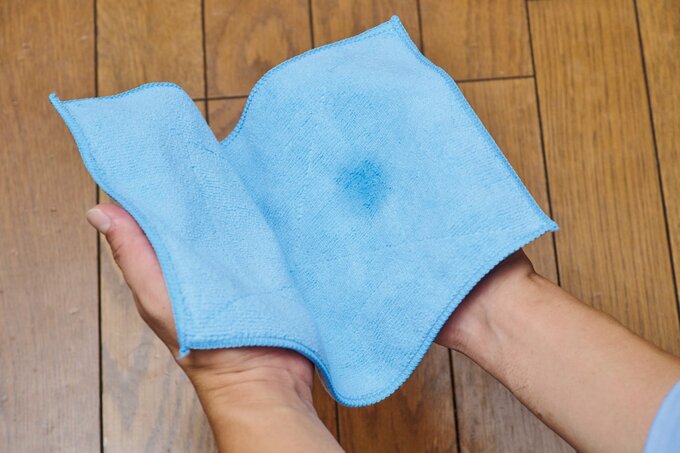 両手でマイクロファイバークロスを広げている手元