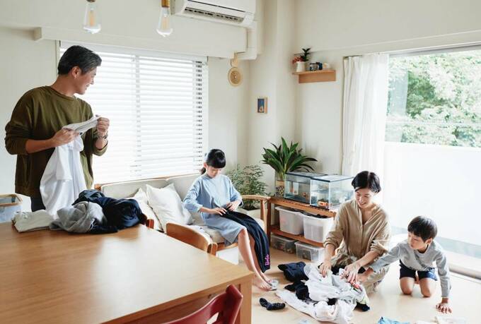 リビングに洗濯ものをたたむ家族