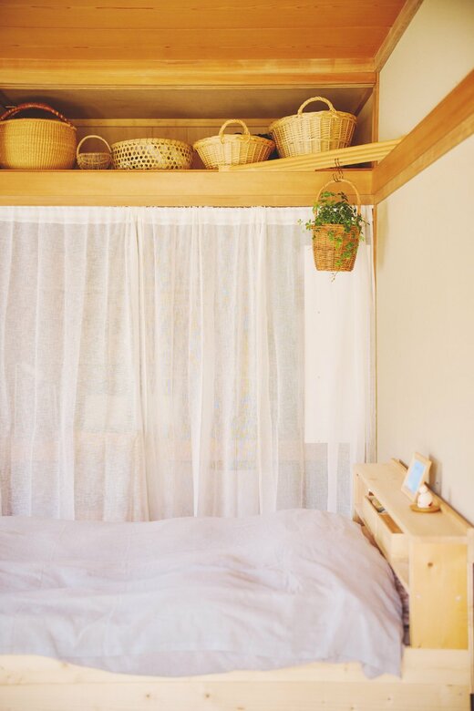 ベッドサイドにかけられた透け感のある白いカーテン