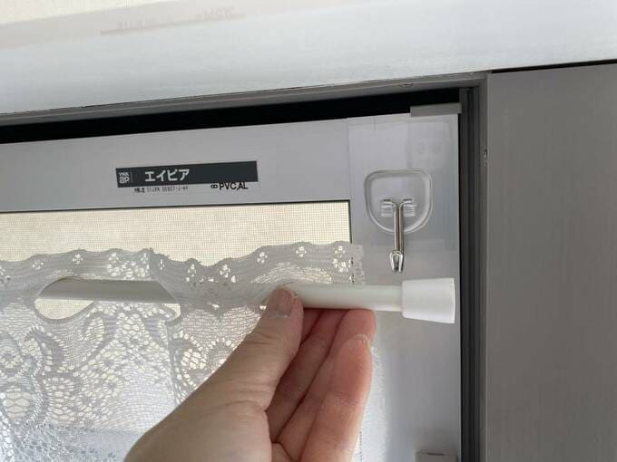 フックにつっぱり棒をかける様子