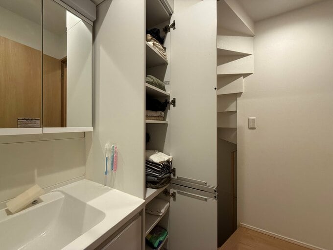 洗面台横のパントリーに、家族の洋服を収納