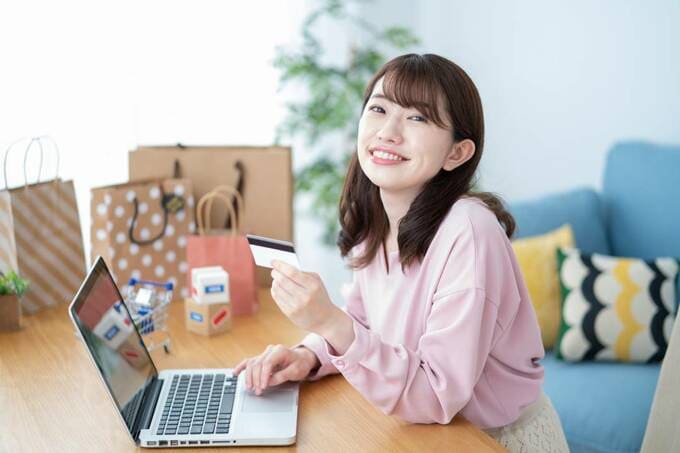 パソコンの目の前でカードを持つ女性