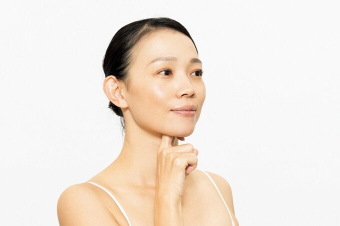 あごに人さし指を当てる女性