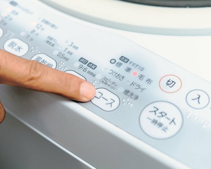 洗濯機のコースボタンを押す様子