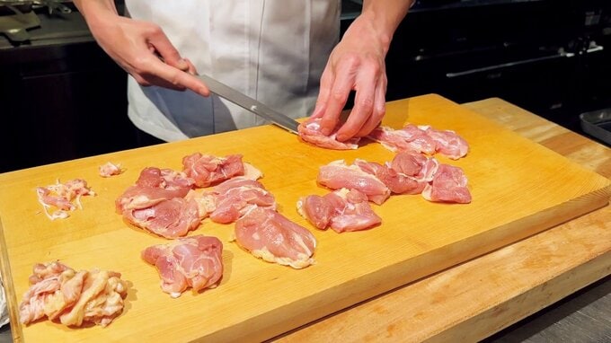 鶏肉を包丁でカットしている様子