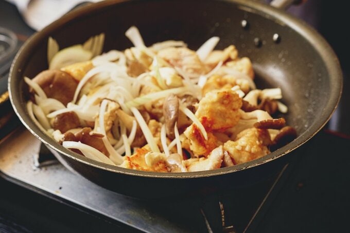 フライパンで肉と野菜を炒める