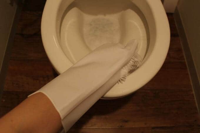 手袋をはめてトイレ掃除