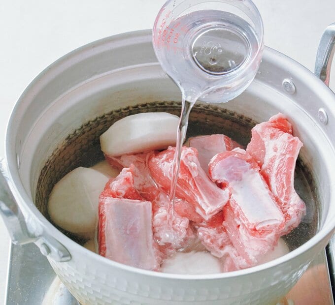 大根と豚スペアリブが入った鍋に水を入れる