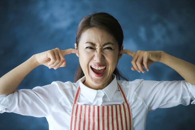 耳をふさぐ女性