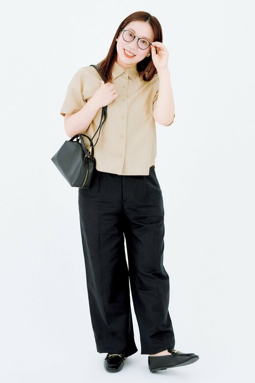 黒いバッグを肩にかけた黒縁眼鏡の女性