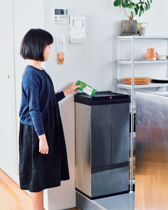 ゴミ箱にゴミを入れる女性