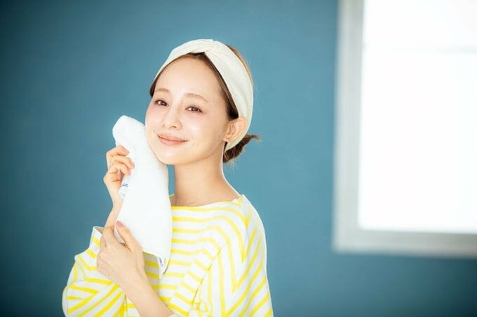 顔にタオル女性