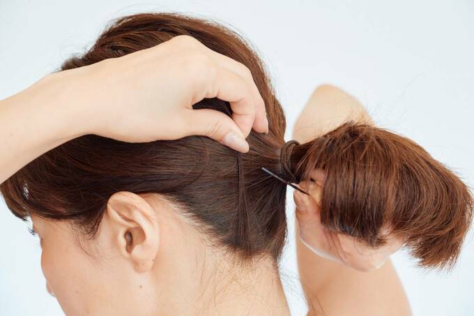 落ちてきた後れ毛をアメピンで留める様子
