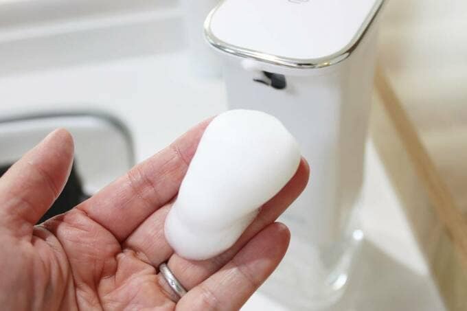 手に白ボタンの泡