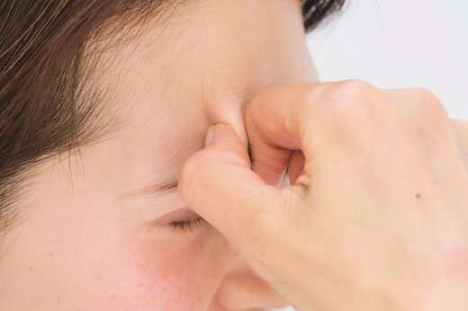 まゆ毛をつかむ女性