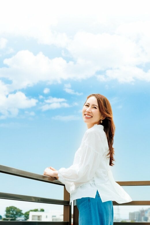 青空の下で微笑む堀井さん