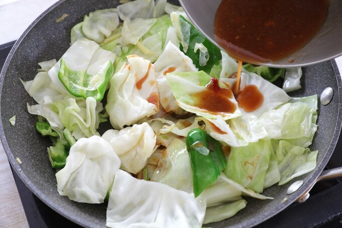 キャベツに調味料を入れて炒める