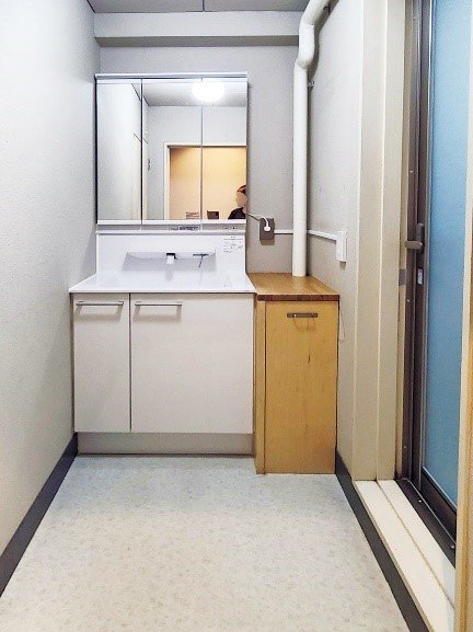 棚の上にパイプが見えている洗面所