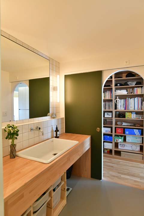 壁の白いタイルとシンプルなデザインの洗面台