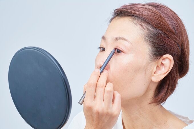 アイラインを引く女性