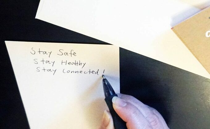 紙に「Stay Safe」を書く様子