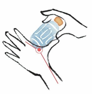 「合谷」という手のツボにペットボトルを当てる