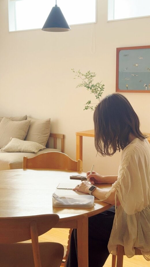 テーブルで書き物をする女性