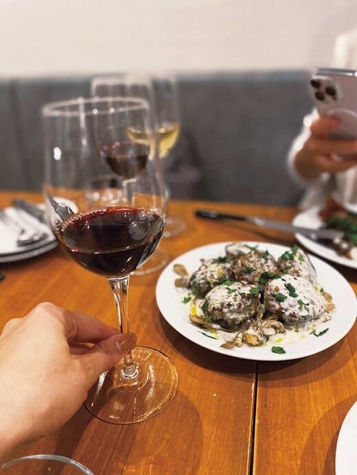 ワインを片手に持ち食事を楽しむ様子