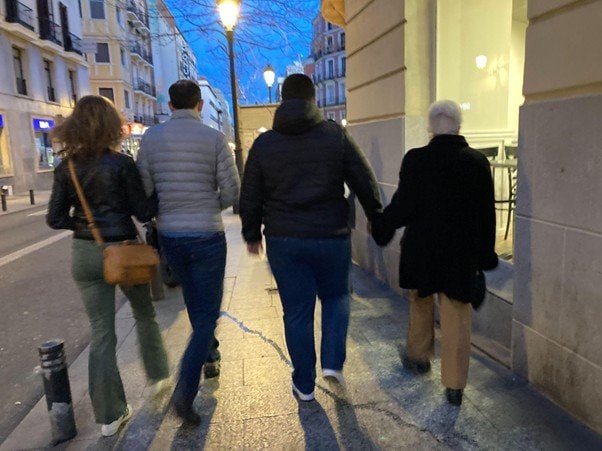 腕を組んで歩く家族の姿