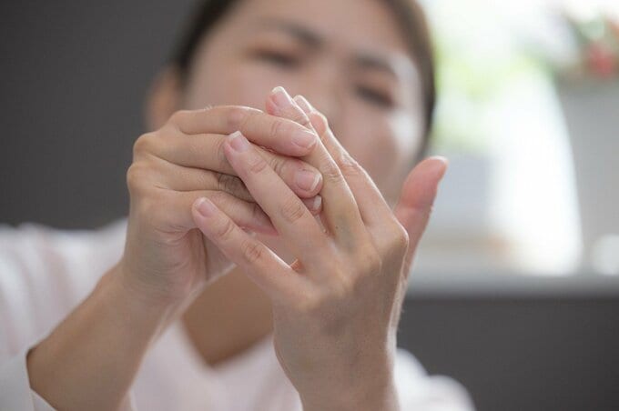 指先をマッサージする女性の画像