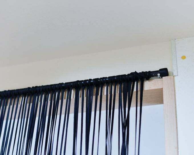 裏側ではつっぱり棒をクギにのせてキープ