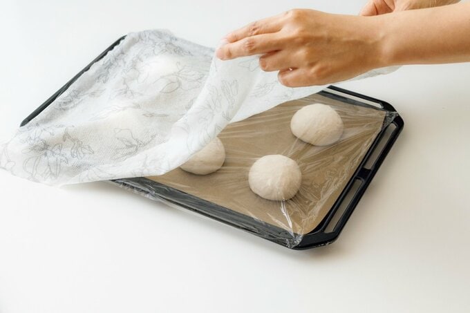 ラップと濡れふきんをかけてパン生地を発酵させる様子