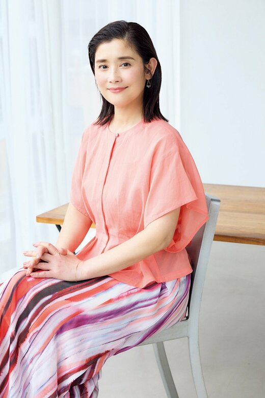 椅子に座って微笑む石田ひかりさん