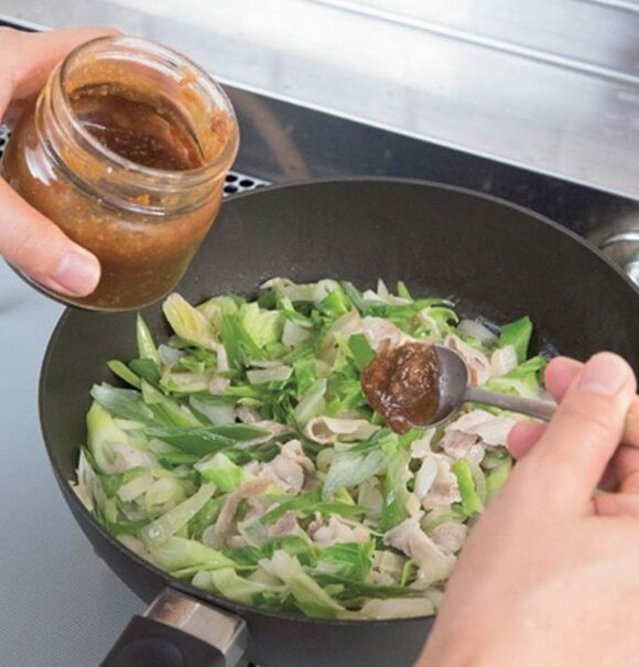 肉野菜炒めをはちみつみそで仕上げる様子