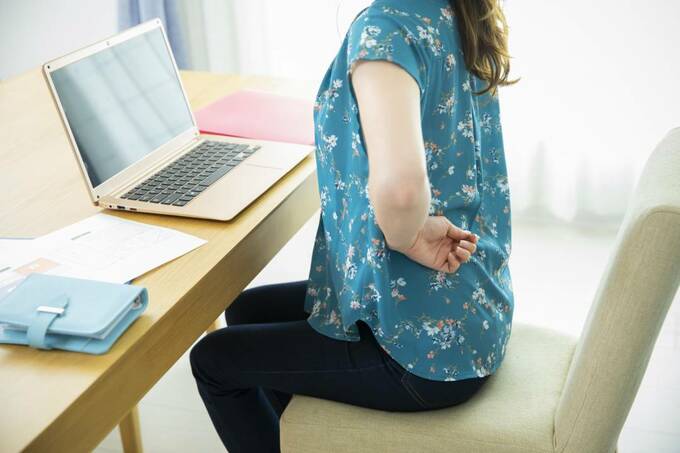 座りながら腰を押さえる様子