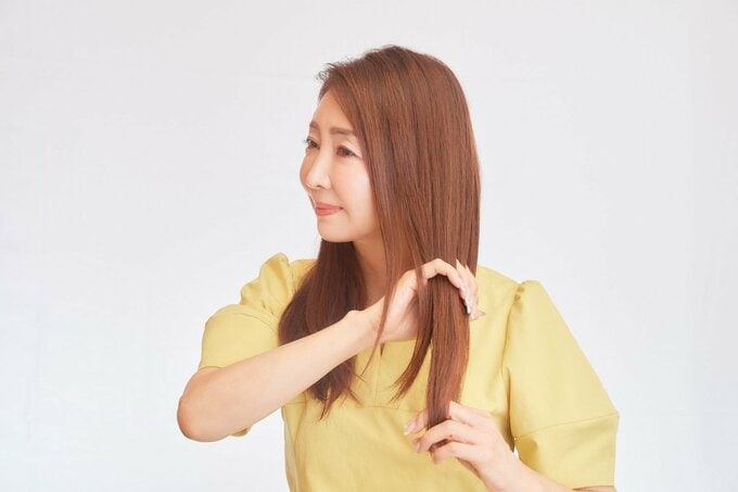 髪にワックスをつける女性