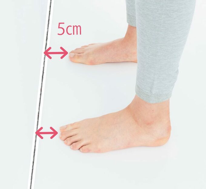 つま先を壁から5cm離して立つ様子