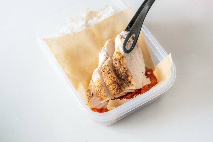 ご飯の上にクッキングシートを敷いて鶏肉をのせる