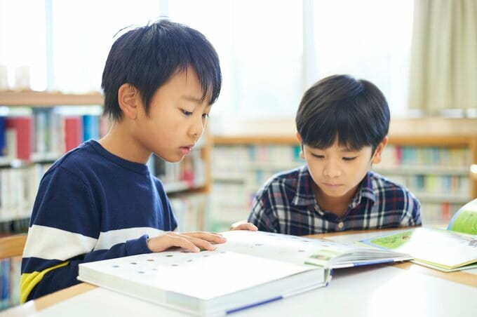 図書館で本を読む小学生