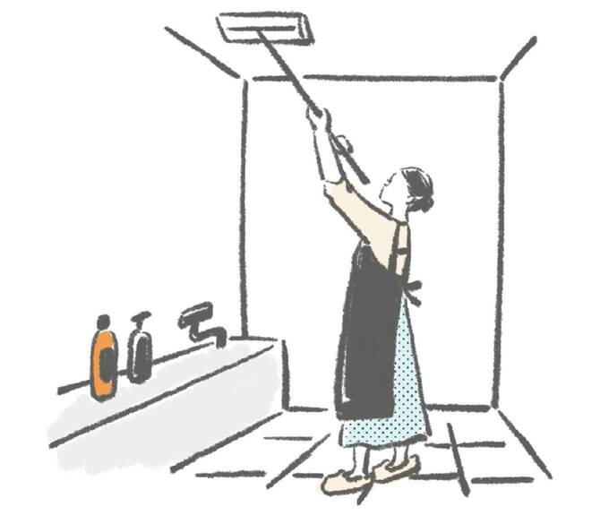 浴室の天井を掃除する女性