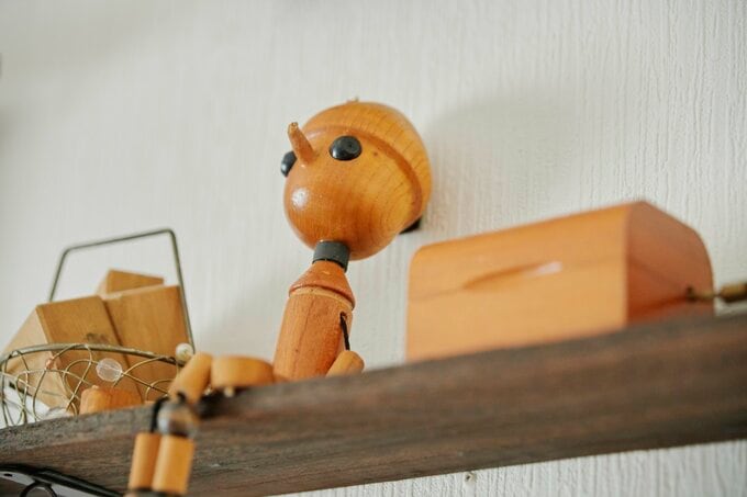 ダイニングの壁の小 さな棚。愛らしいピ ノキオが座っていま す。「100円ショ ッ プで買 った棚に、息 子と娘の思い出の品 を飾っています。い つも見えるところに 置いておきたくて」