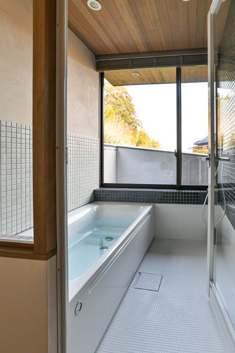 大きな窓から明るい日差しと景色を取り込むバスルーム