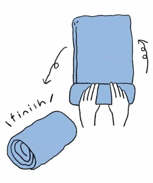 折りたたんだワンピースを裾部分からくるくると筒状に巻く様子